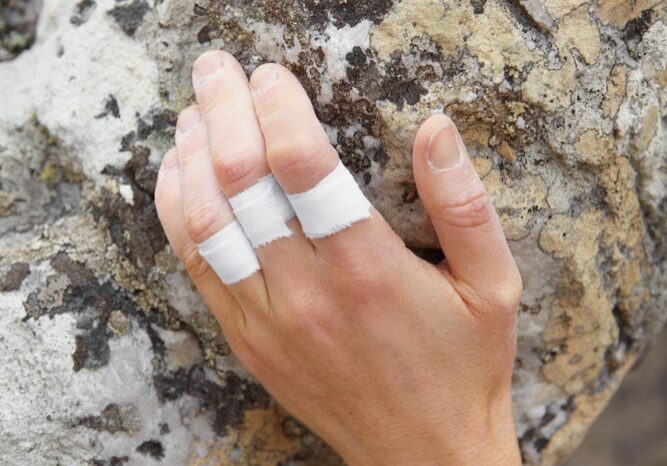 Persona, montaña y escalada en roca o cinta adhesiva para los dedos en la mano