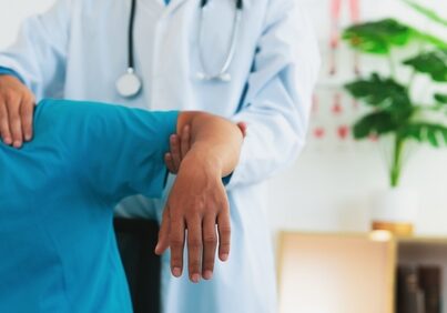 Ein Physiotherapeut behandelt einen Mann mit Schulterschmerzen